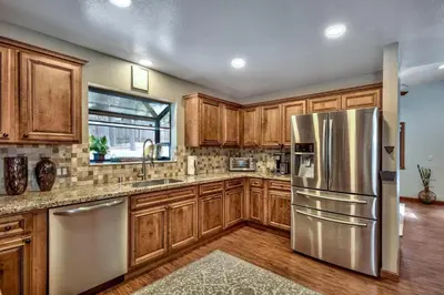 a kitchen with wooden cabinets and a stainless steel refrigerator at 1760T Thunderbird Cabin in South Lake Tahoe