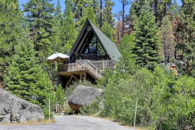 a tree house with a deck in the woods at 3001R Reindeer A Frame Cabin in South Lake Tahoe