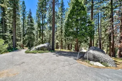 a road with two large rocks in a forest at 3001R Reindeer A Frame Cabin in South Lake Tahoe