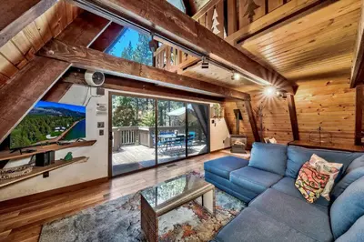 a living room with a blue couch and a large window at 3001R Reindeer A Frame Cabin in South Lake Tahoe