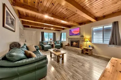 a living room with a green couch and a fireplace at 2782B Tahoe River Chalet in South Lake Tahoe