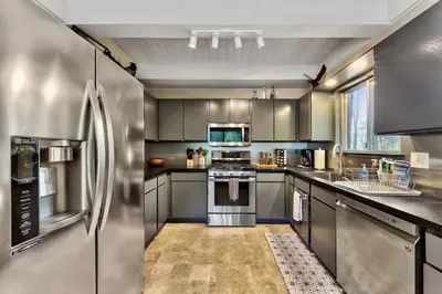 a kitchen with stainless steel appliances and gray cabinets at 2782B Tahoe River Chalet in South Lake Tahoe