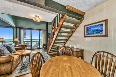 a living room with a wooden table and a spiral staircase at 920 Bal Bijou in South Lake Tahoe