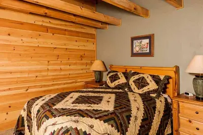 a bedroom with a bed with a wooden wall at Tahoe Moose Lodge 1170AC in South Lake Tahoe