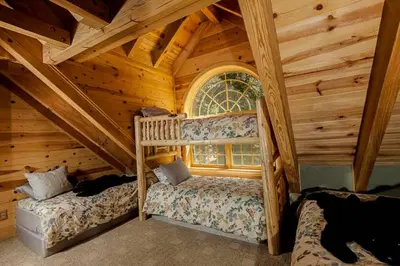 a bedroom with two beds in a log cabin at Tahoe Moose Lodge 1170AC in South Lake Tahoe