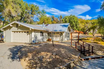 a large white house with a garage at Yosemite Wooded Hills, Pool Table, Fitness, Views in Oakhurst