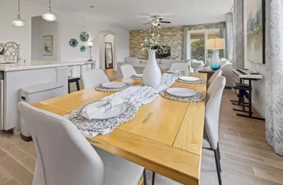 a dining room with a wooden table and white chairs at Casita Tulare in Tulare