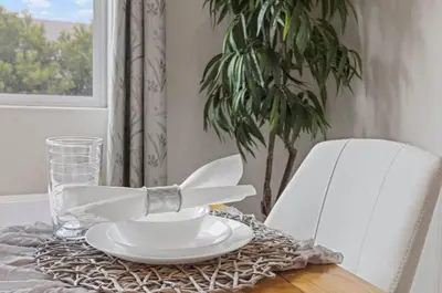 a table with a plate and a glass and a plant at Casita Tulare in Tulare