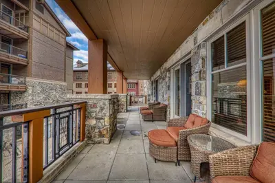 a balcony with chairs and tables on a building at Big Horn Lodge 202 by East West Hospitality in Truckee
