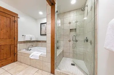 a bathroom with a shower and a tub and a sink at Big Horn Lodge 202 by East West Hospitality in Truckee