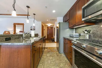 a large kitchen with wooden cabinets and stainless steel appliances at Big Horn Lodge 202 by East West Hospitality in Truckee