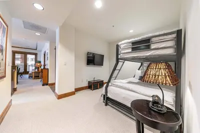 a bedroom with a bunk bed and a table at Big Horn Lodge 202 by East West Hospitality in Truckee