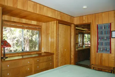 a bedroom with wooden walls and a window and a bed at 68 Wawona Dome View in North Wawona
