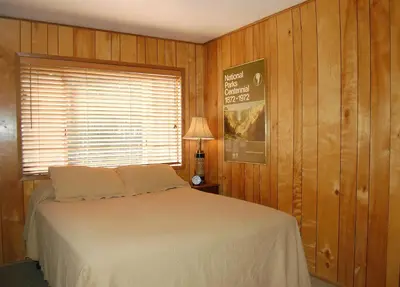 a bed in a room with wooden walls and a window at 68 Wawona Dome View in North Wawona