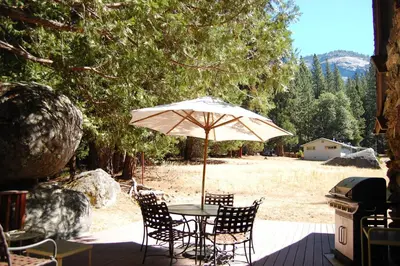 a table and chairs under an umbrella on a patio at 68 Wawona Dome View in North Wawona