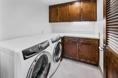 a washing machine in a kitchen with wooden cabinets at Luxurious Truckee Rental Hot Tub and Valley Views in Truckee