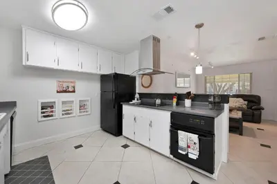a kitchen with white cabinets and a black refrigerator at Arden Calexpo HotTub Pool Firepit BBQ NoPetFee in Sacramento