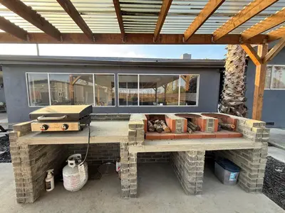 a patio with a stone grill with a window at GUEST RANCH HOUSE w POOL access near NATL PARKS in Dinuba