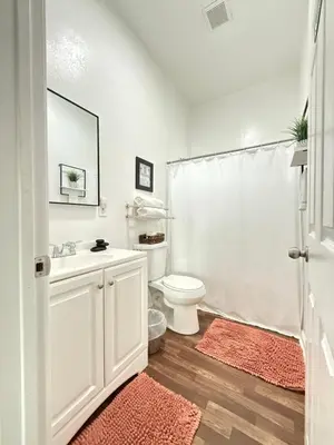 a white bathroom with a toilet and a sink at GUEST RANCH HOUSE w POOL access near NATL PARKS in Dinuba