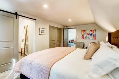 a bedroom with a large bed with white sheets at Miztec Mountain - Ping pong & basketball hoop game in South Lake Tahoe