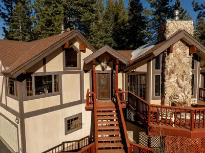 a home with a wrap around porch with a deck at Spacious Tahoe City Home with Foosball and Lake Views in Tahoe City