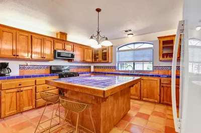 a kitchen with wooden cabinets and a large island at Happy Hours - Beautiful Quiet Comfortable Suite #3 in Visalia