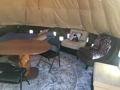 a room with a table and chairs in a tent at Big Glamping Teepee in Bodfish