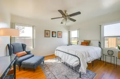 a bedroom with a bed and a chair and windows at 19 Mi to Sequoia Natl Park Mtn-View Woodlake Gem in Woodlake