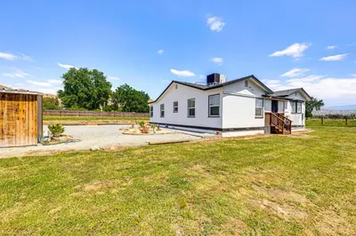 a white house with a fence and a yard at 19 Mi to Sequoia Natl Park Mtn-View Woodlake Gem in Woodlake