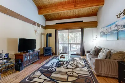 a living room with a couch and a tv at The Cozy Condo in Kingswood Estates