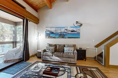 a living room with a couch and a large window at The Cozy Condo in Kingswood Estates