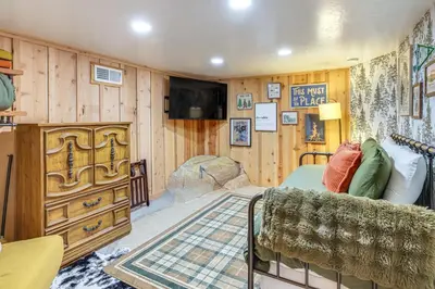 a room with a tv and a couch and a dresser at Walk to Golf, Lake Twain Harte Cabin with Fireplace in Twain Harte