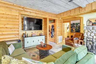 a living room with a couch and a television at Walk to Golf, Lake Twain Harte Cabin with Fireplace in Twain Harte