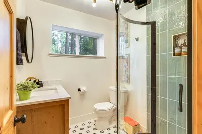 a bathroom with a toilet and a glass shower at Walk to Golf, Lake Twain Harte Cabin with Fireplace in Twain Harte