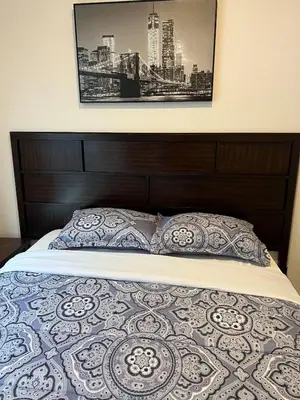 a bed with a wooden headboard and two pillows at Brand New Scenic Sequoia House in Three Rivers