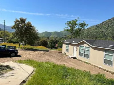 a house with a car parked next to a driveway at Brand New Scenic Sequoia House in Three Rivers