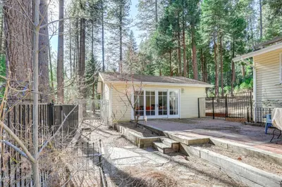 a small yellow house with a porch in the woods at Drive to Major Parks Nature Getaway in West Point in West Point