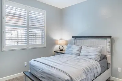 a bedroom with a large bed and a window at Spacious 4BR Home With BBQ, Near Sequoia & Fresno in Hanford