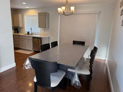 a dining room table with chairs and a kitchen at Luxury Escape in Stockton