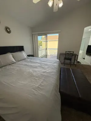 a bedroom with a large white bed and a balcony at Luxury Escape in Stockton