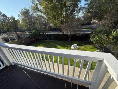 a dog sitting on top of a white wooden deck at Luxury Escape in Stockton