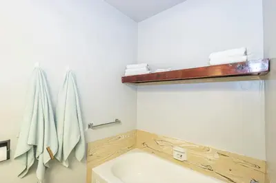 a bathroom with a tub and a sink and towels at Sierra Vista Lookout Lodge for 8 people with Hot tub, deck and trail to waterfalls in North Fork
