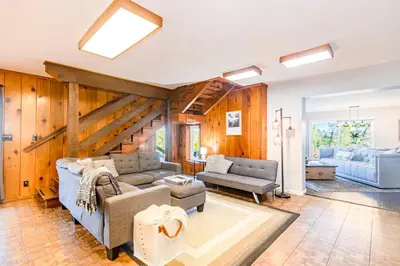 a living room with a couch and a table at Sierra Vista Lookout Lodge for 8 people with Hot tub, deck and trail to waterfalls in North Fork
