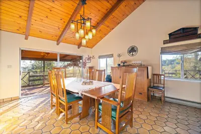a dining room with a wooden table and chairs at 10-acre Forest Villa, 20 miles from Yosemite South in Oakhurst
