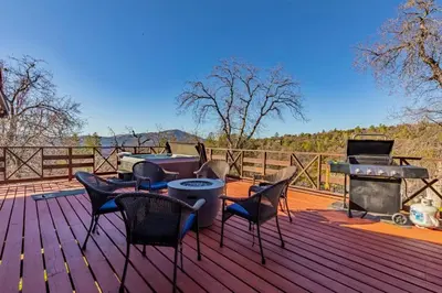 a deck with chairs and a table and a grill at 10-acre Forest Villa, Single Floor, Hot tub, Patio in Oakhurst