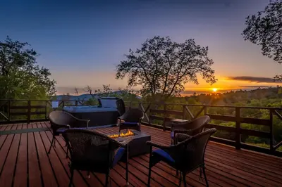 a deck with chairs and a table with a fire pit at 10-acre Forest Villa, Single Floor, Hot tub, Patio in Oakhurst
