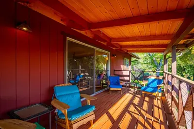 a deck with blue chairs and tables on it at 10-acre Forest Villa, Single Floor, Hot tub, Patio in Oakhurst