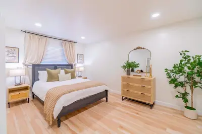 a bedroom with a bed and a dresser and a mirror at Emerald Escape - UNR & Pet Friendly in Reno