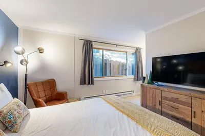 a bedroom with a bed and a television and a chair at Lakeside Life in Tahoe Vista