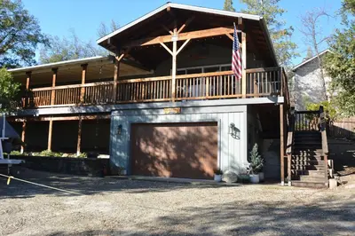 a house with a garage and an american flag at Ledge House-Lake Area Free Night Special in Bass Lake
